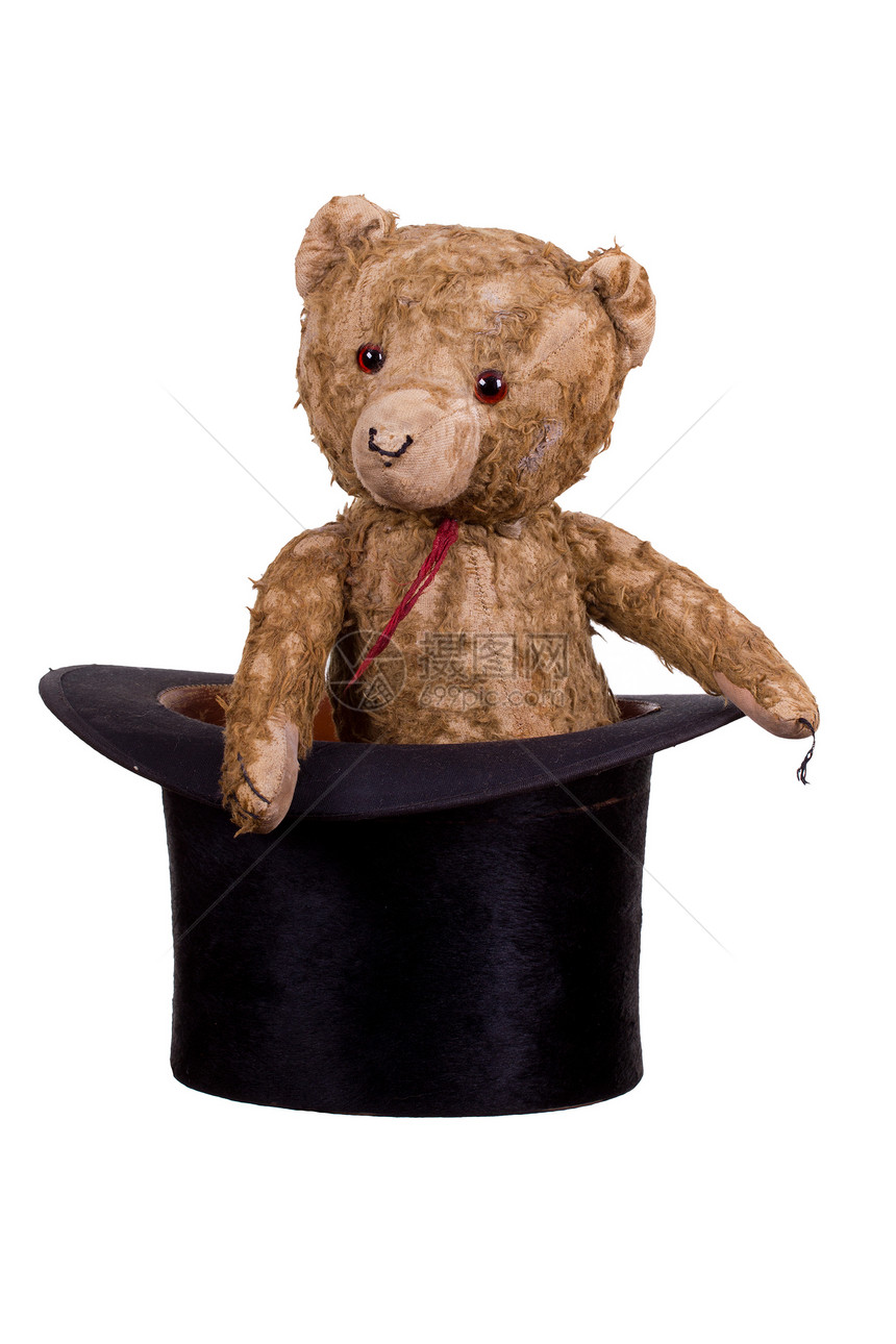 坐在旧黑帽子上的老泰迪熊童年乐趣棕色黑色毛皮帽子礼物白色玩具手工图片