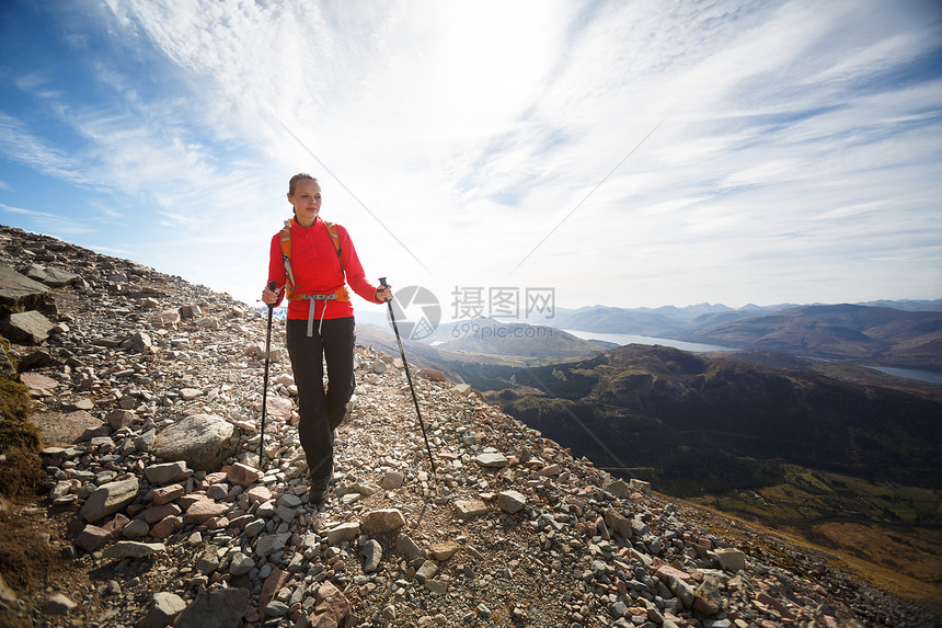 漂亮的年轻女性徒步旅行者上山远足高度活动耐力女士爬坡远足者越野太阳享受图片