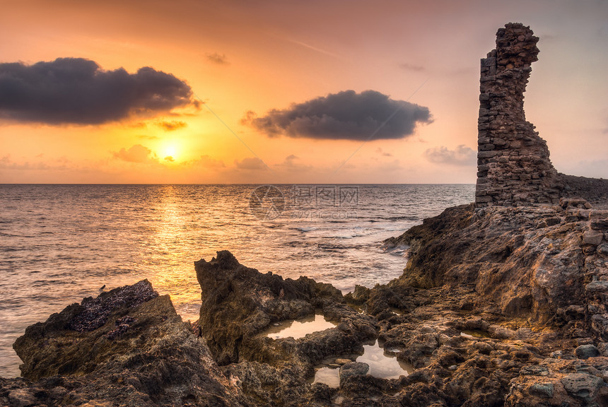 海面和岩石海岸的日落 与古老的废墟地平线水池风景海景建筑学太阳场景阳光旅行橙子图片