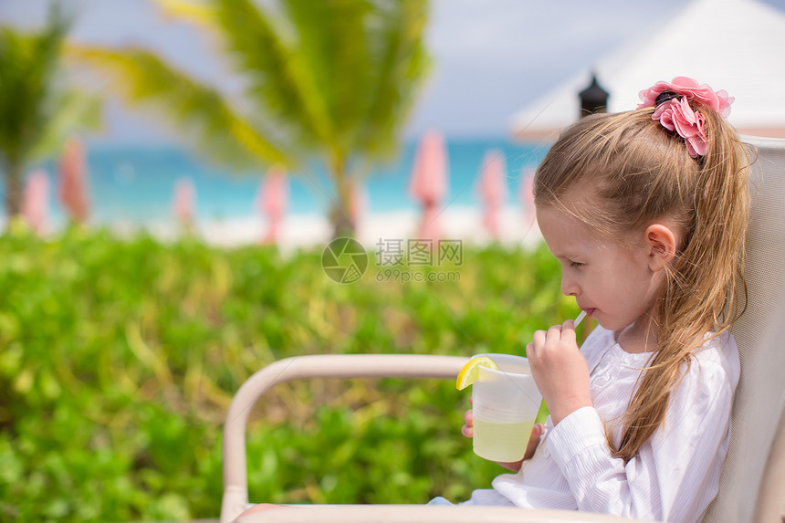 可爱的小女孩 在户外咖啡厅喝果汁童年快乐餐厅食物假期女孩孩子女性热带桌子图片