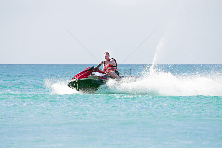 年轻人骑着喷气式飞机 在卡比巴海上航行海滨乐趣运动海洋奢华海滩喷射速度白色滑雪图片