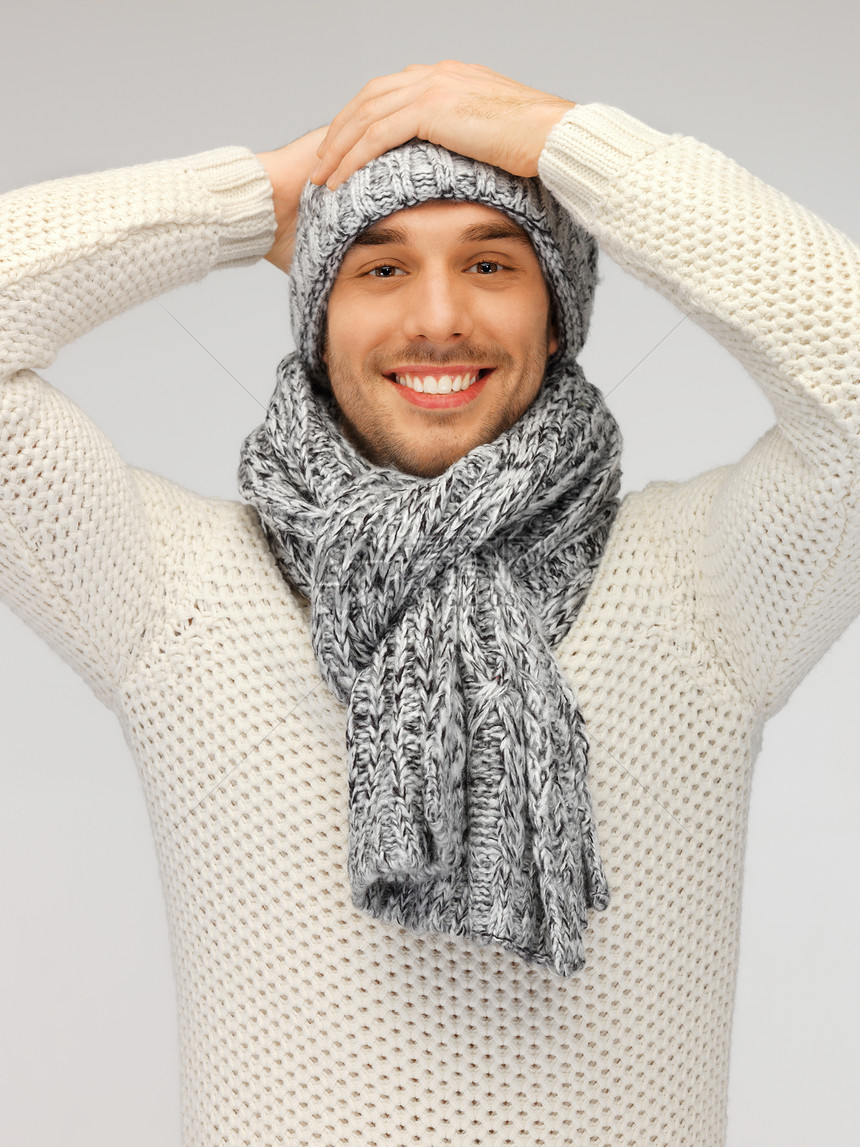 穿着温暖毛衣 帽子和围巾的英俊男子快乐微笑小伙子外套季节男性青年衣服棉被羊毛图片