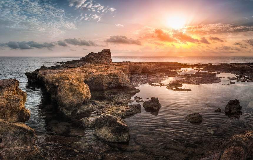 海和落岩海岸的日落海洋废墟场景旅行海景石头海滩阳光支撑风景图片