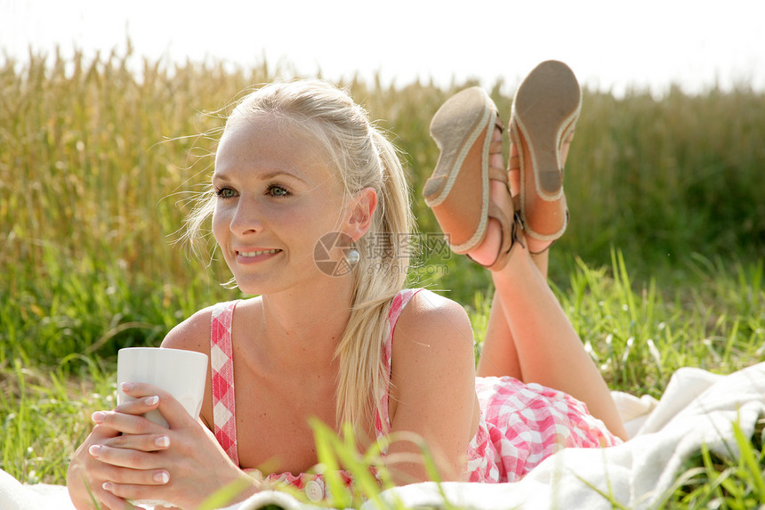 喝咖啡的年轻妇女假期服装旅游野餐草地咖啡喜悦裙子休息拿铁图片