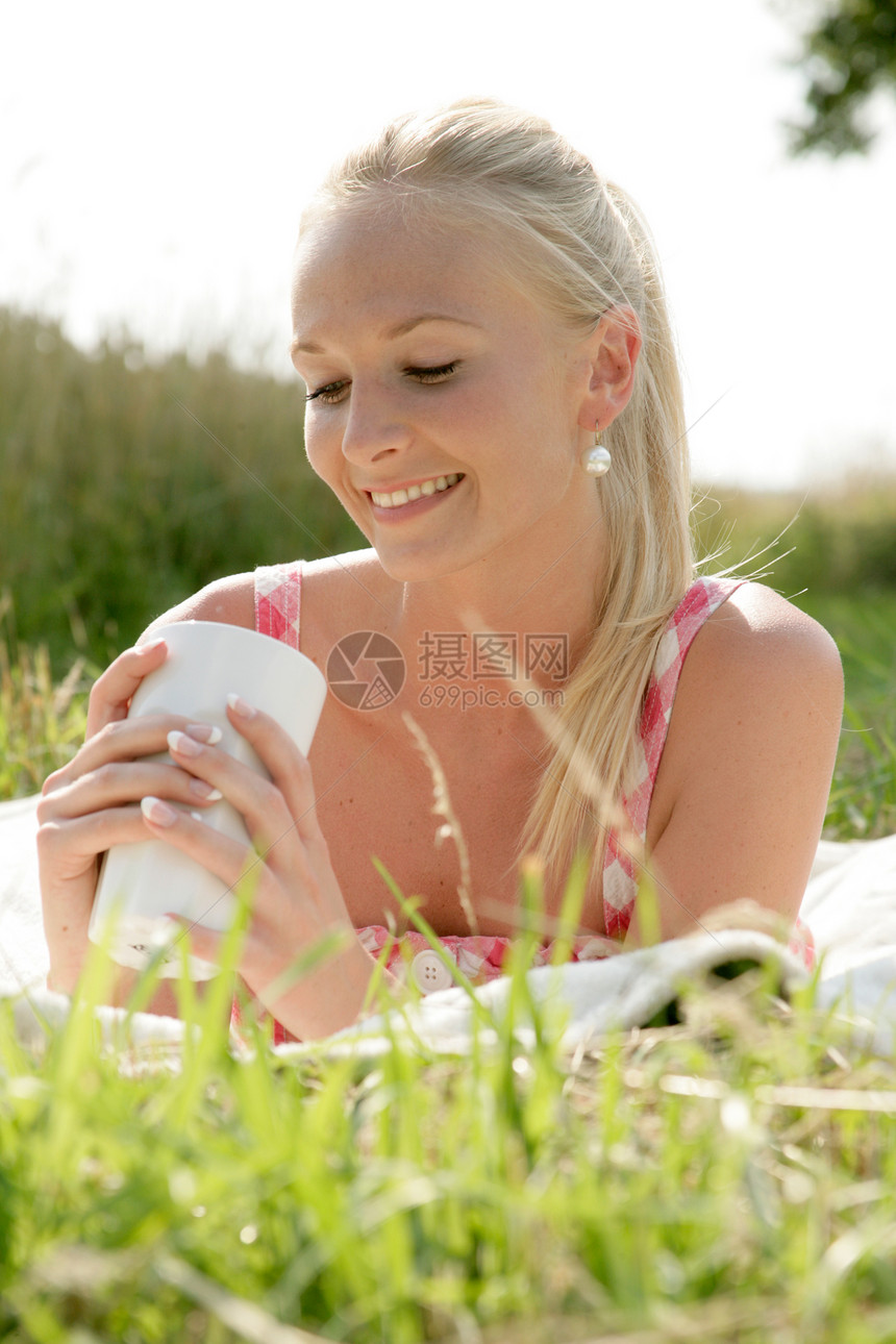 喝咖啡的年轻妇女女孩金发女郎玻璃闲暇咖啡旅游毯子假期草地服装图片