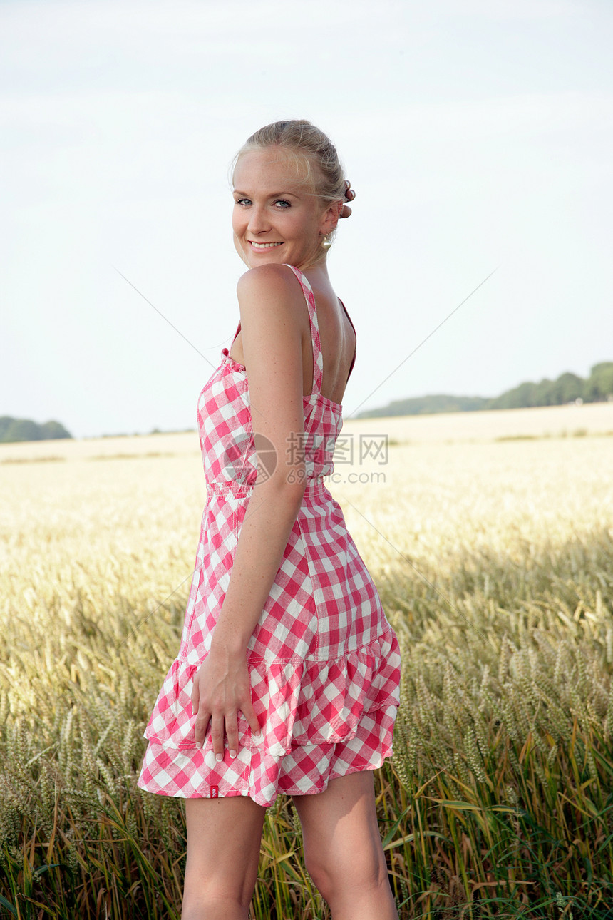 身在大自然中的年轻女性远足场地裙子粮田金发女郎假期乐趣草地闲暇微笑图片
