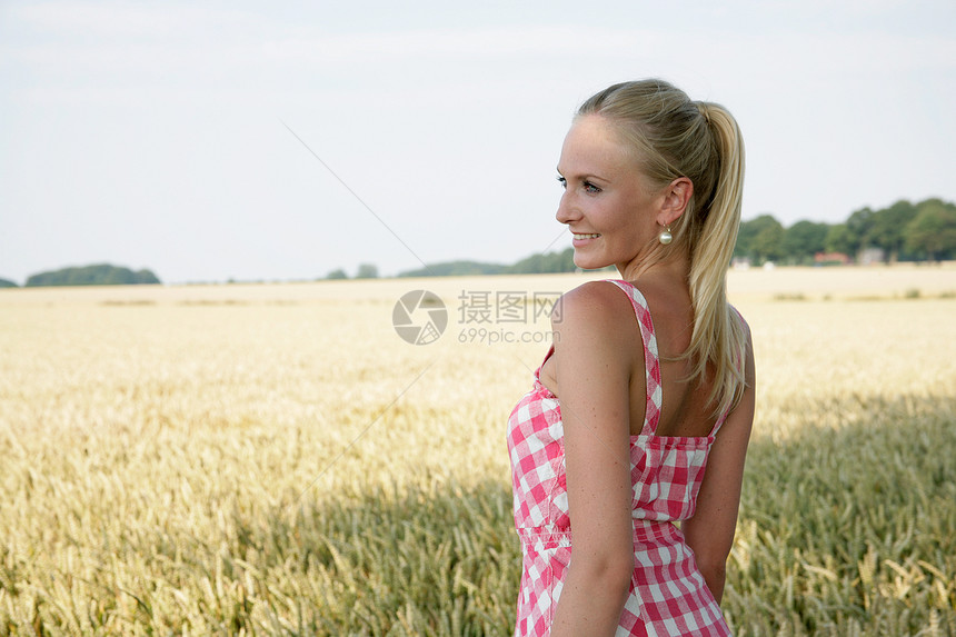 身在大自然中的年轻女性远足微笑跑步场地女士闲暇裙子金发女郎假期玉米地图片