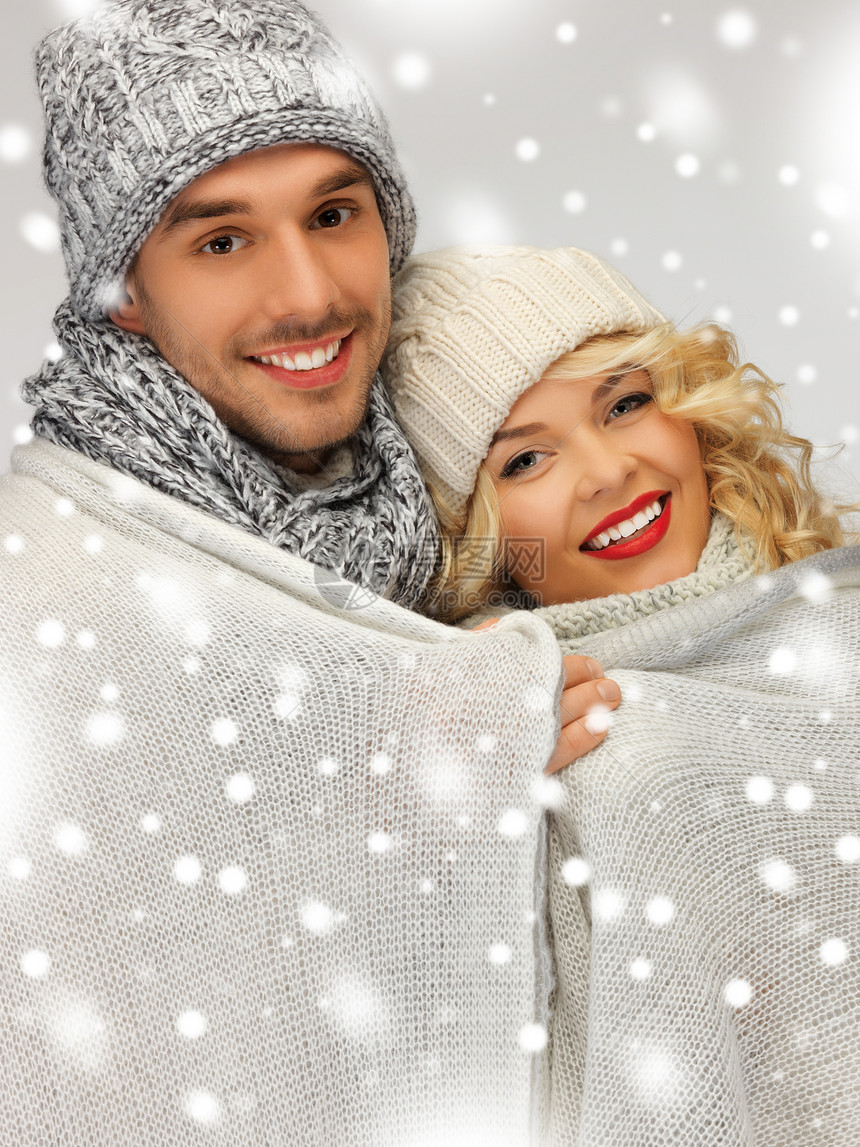 在温暖的毯子下的家庭夫妇季节家庭雪花帽子羊毛快乐微笑女士领带休息图片
