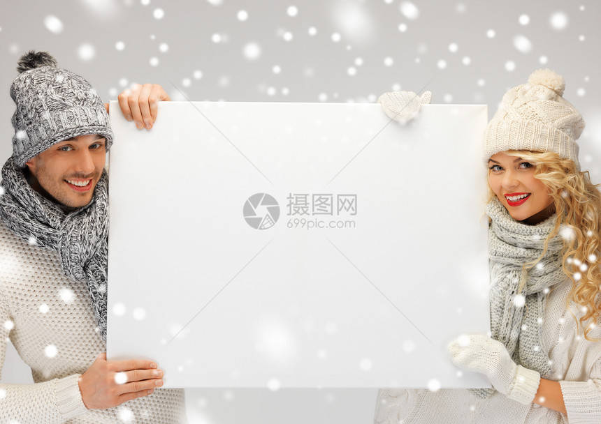 一对夫妇在冬衣中的情侣 拿着空白板广告毛衣棉被广告牌围巾家庭微笑木板男性女士图片