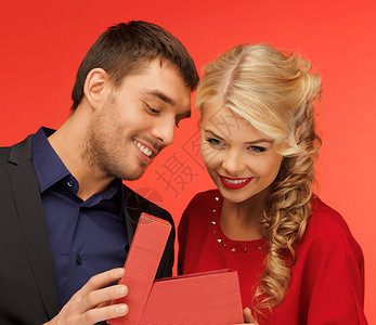 男人和女人在礼品箱里看衣服购物微笑庆典盒子展示女性夹克快乐男性背景图片