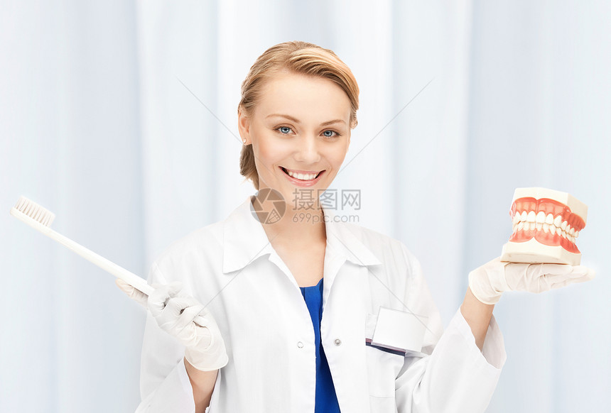 有牙刷和下巴的有吸引力的女医生治疗女性女士搪瓷假牙口腔科房间教学药品卫生图片