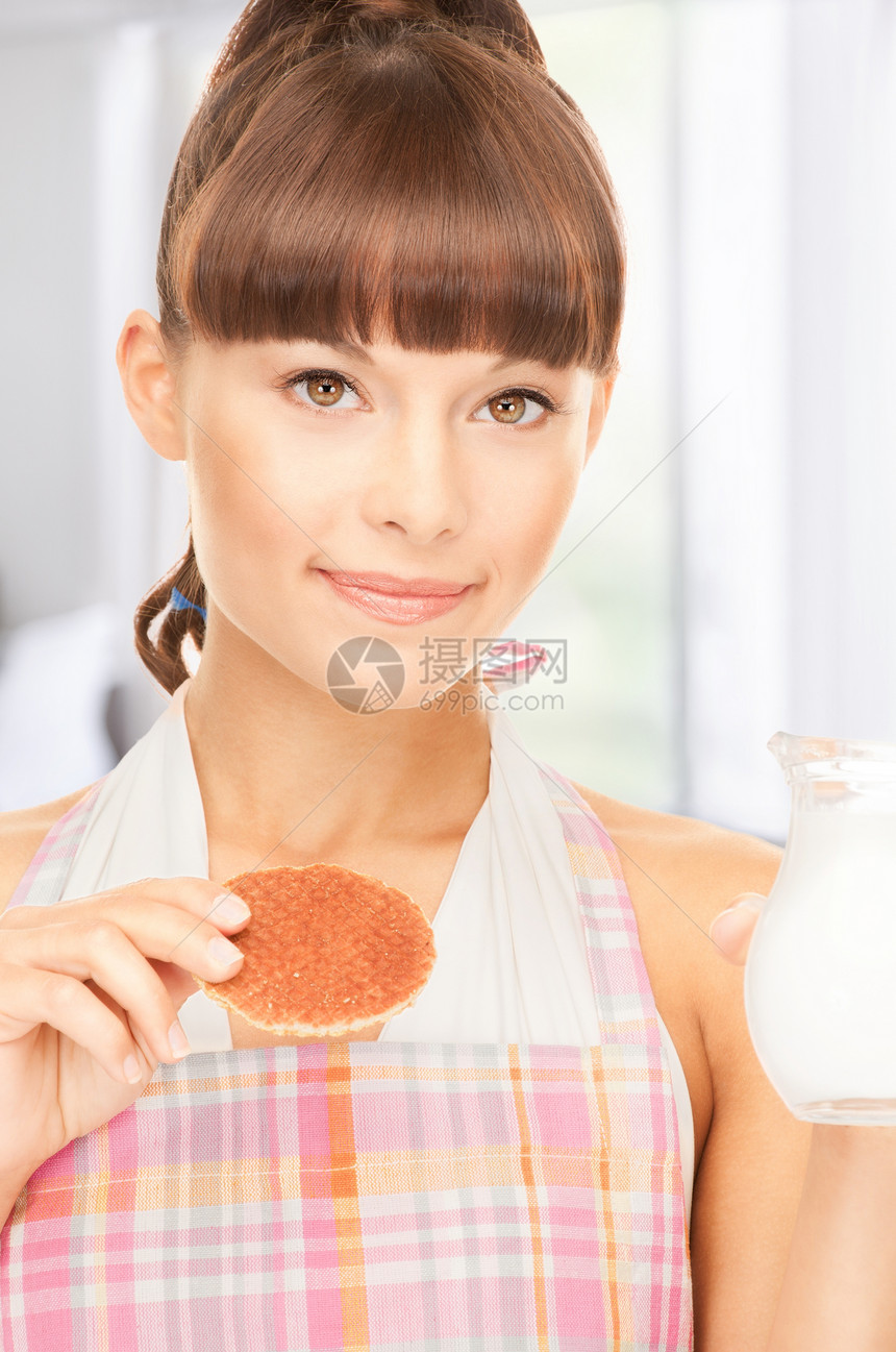 配奶和饼干的家庭主妇厨房烘烤牛奶烹饪女性食物微笑女孩早餐围裙图片