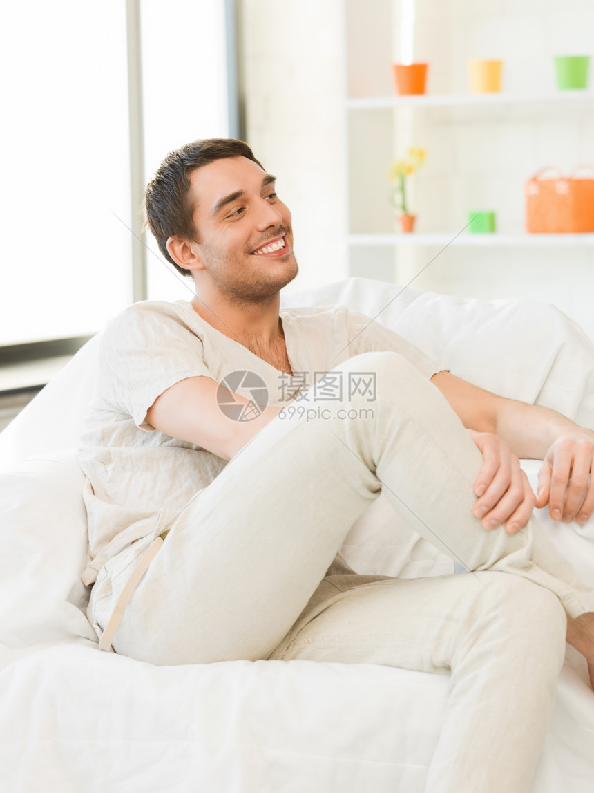 坐在沙发上的帅哥享受小伙子时间乐趣男性幸福赤脚喜悦成人闲暇图片