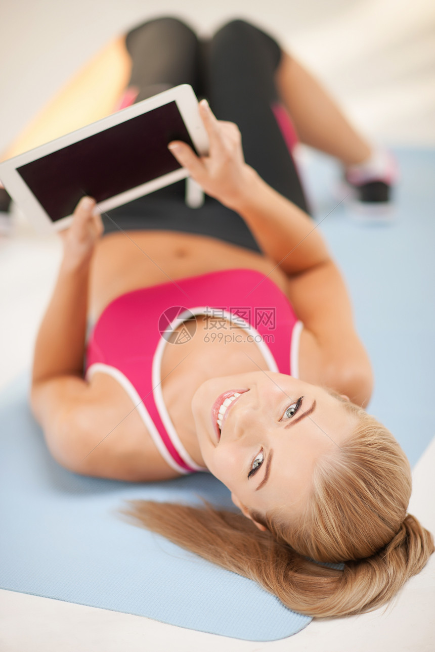 妇女用平板电脑躺在地上地面训练网络有氧运动柜台女性程序培训师教练运动装图片