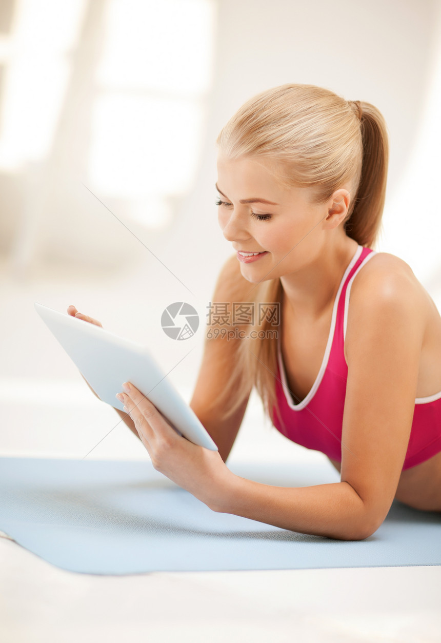 妇女用平板电脑躺在地上药片身体软垫运动员腹肌程序女孩说谎运动训练图片