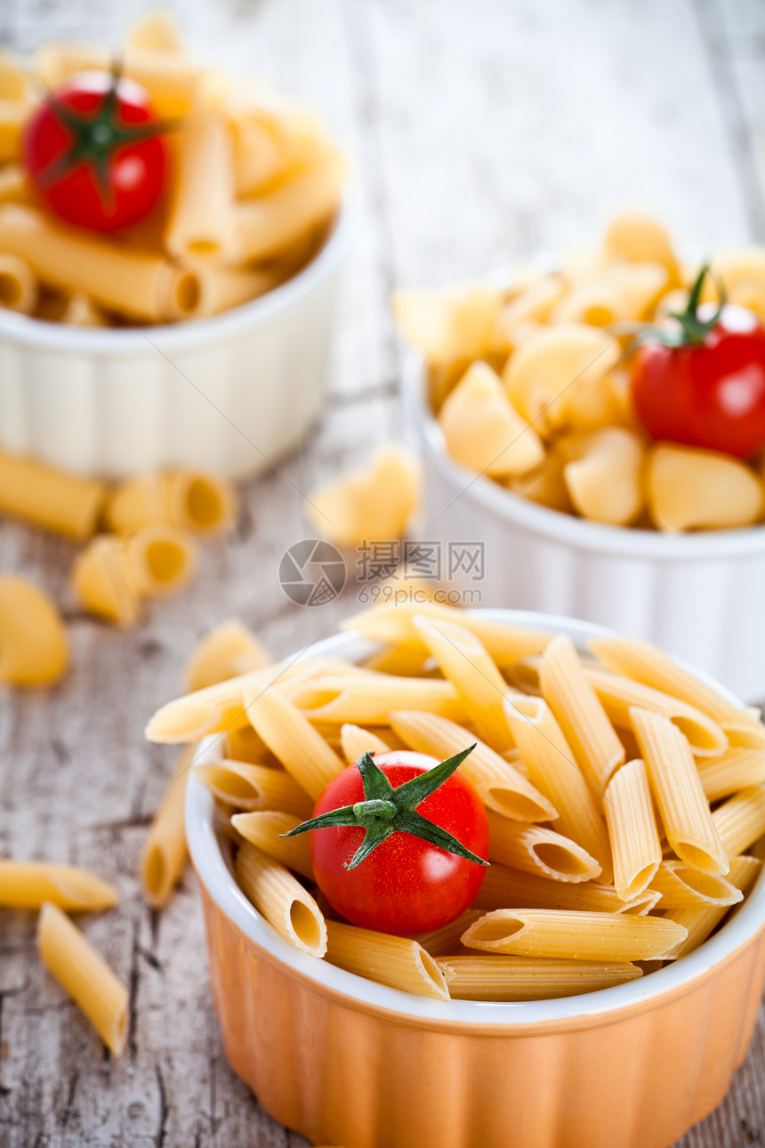 未烹煮的意大利面和樱桃番茄红色美食乡村烹饪宏观面条桌子蔬菜香料食物图片