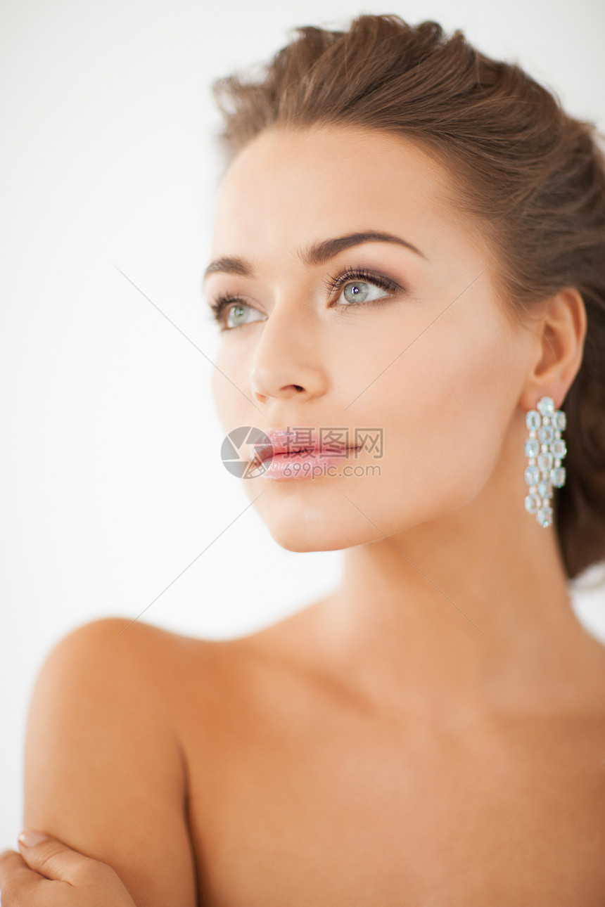 妇女佩戴闪亮的钻石耳环奢侈品新娘水晶珠宝女孩女性石头首饰魅力广告图片