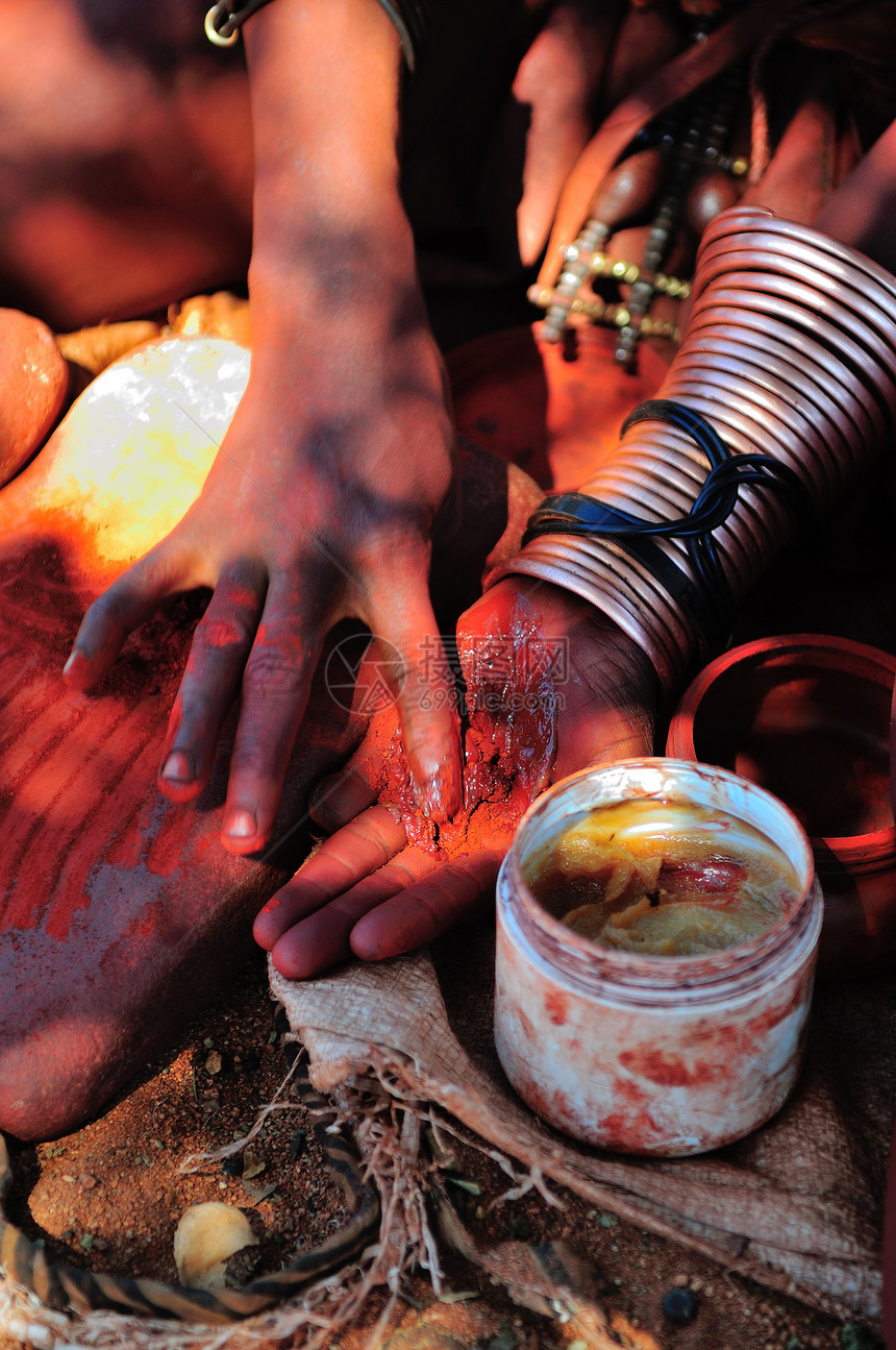 Himba妇女混合红阿赫和石油果冻图片