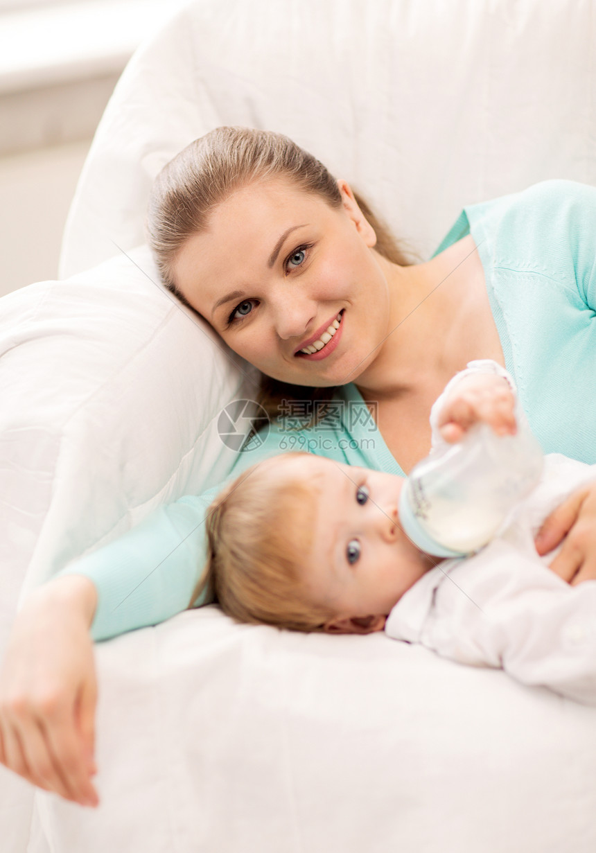 母亲和可爱的婴儿 有喂奶瓶长椅拥抱父母牛奶儿子微笑奶瓶孩子瓶子食物图片