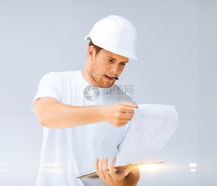 男性建筑师在寻找蓝图开发商工作服工作房间技术员装修方案项目工程师安全帽图片