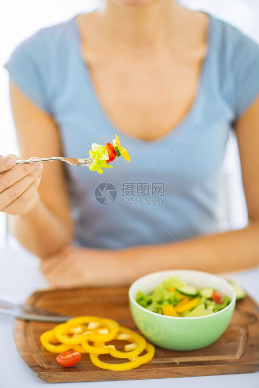 手握蔬菜叉子的女子女性胡椒损失营养烹饪厨房早餐重量桌子午餐图片