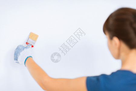 墙上涂着油漆刷的妇女手套墙壁画笔装修画家刷子工具乐器染料空白背景图片