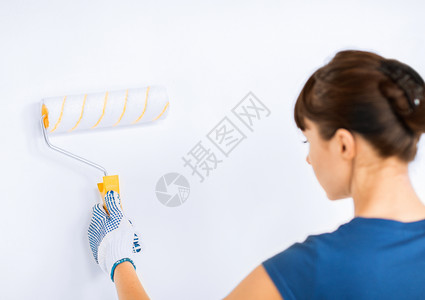 妇女用滚滚和油漆涂墙彩色手套墙壁乐器家务女孩绘画装修画家工具空白背景图片