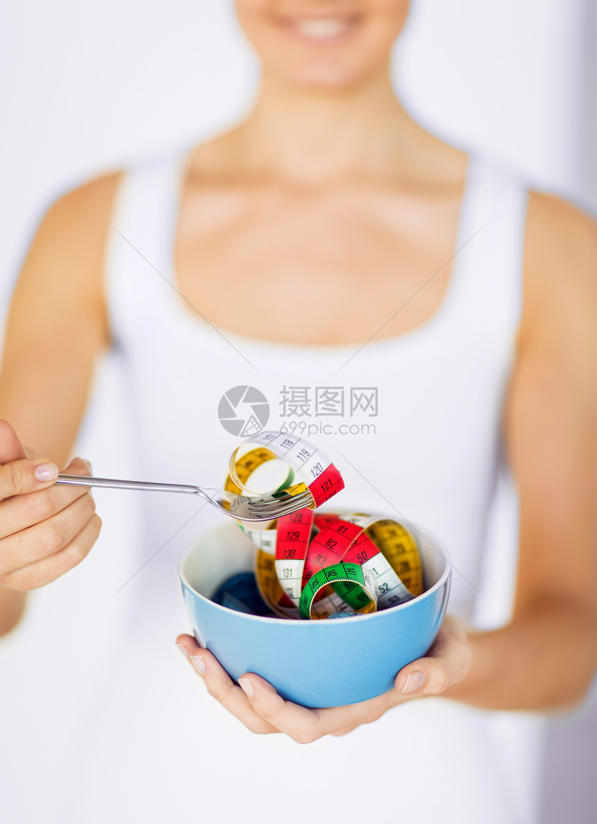 妇女手握水碗和测量胶带运动员低脂肪健康燃烧女孩数字节食培训师身体饮食图片