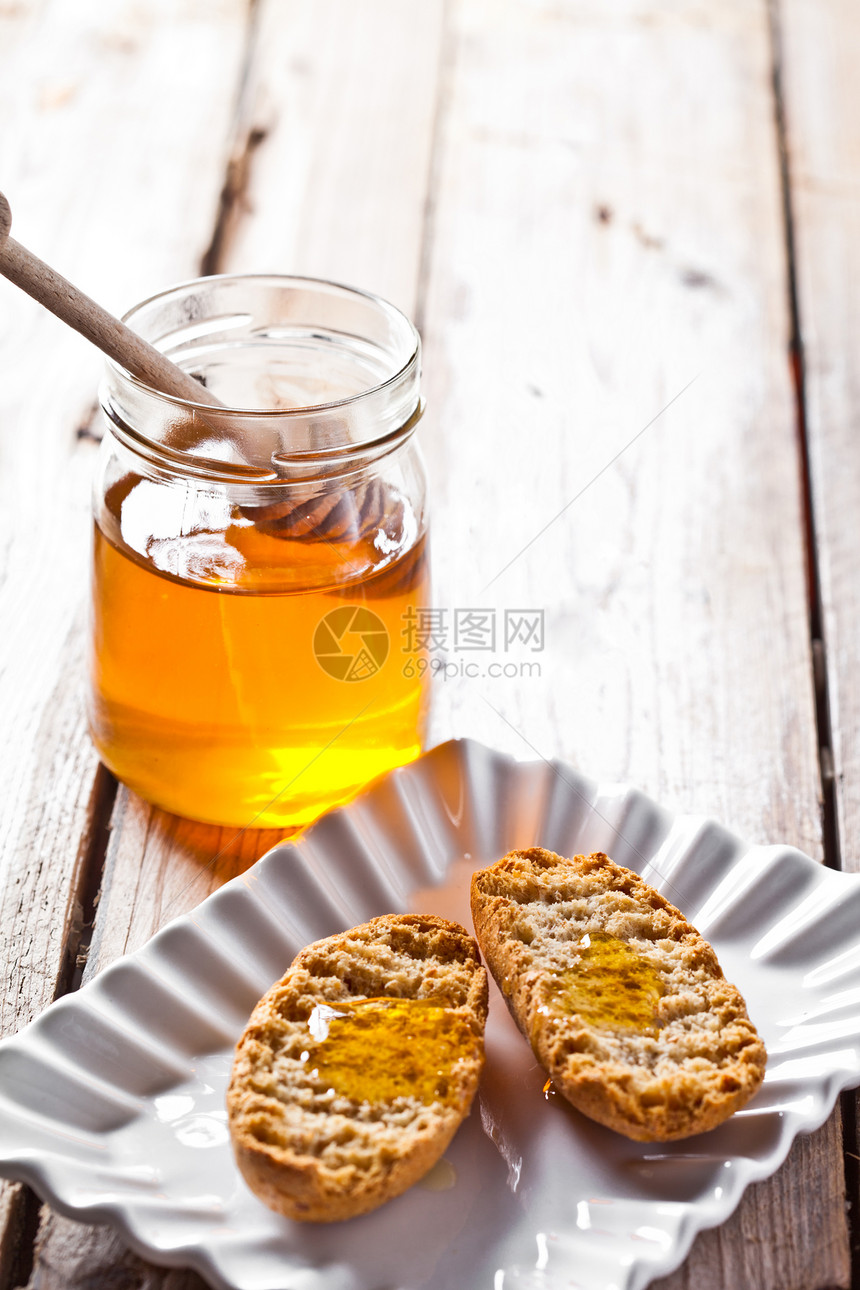 盘子里的饼干和蜂蜜乡村美食垃圾食物营养早餐糕点勺子制品木板图片