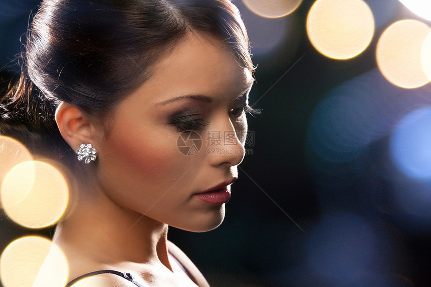 妇女穿着戴钻石耳环的晚礼服富裕夜生活城市社会奢华派对珠宝首饰客人俱乐部图片