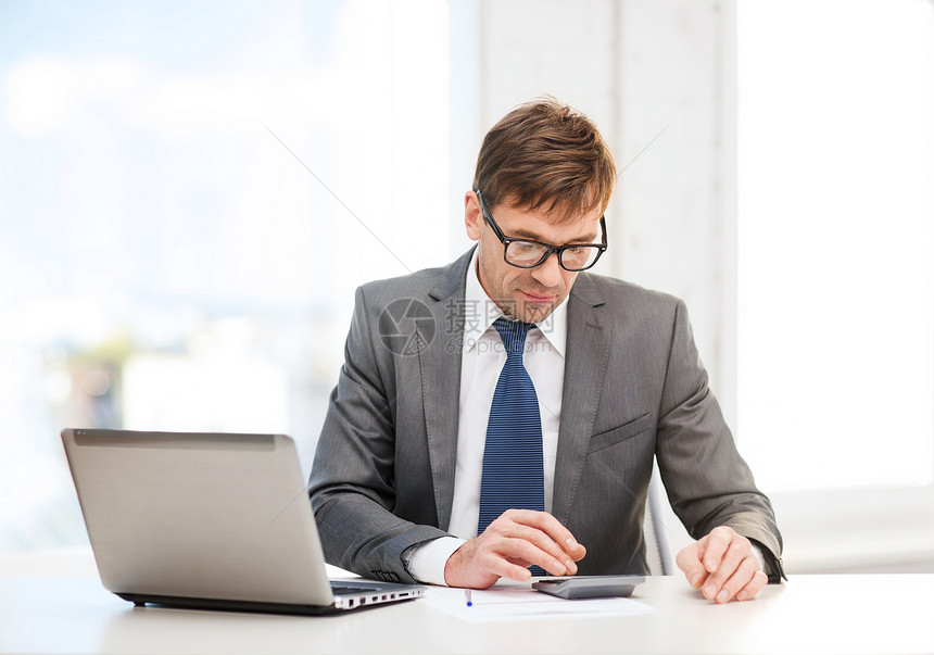 拥有计算机 纸张和计算器的商务人士男性老师报告办公室企业家领带套装统计男人老板图片