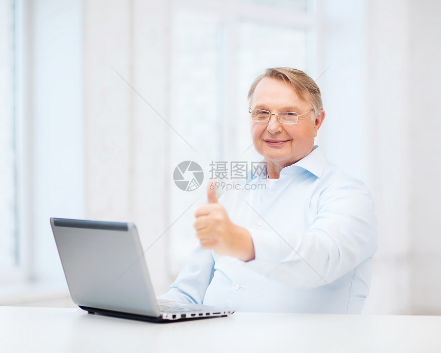 老人用笔记本电脑显示拇指学习微笑商务老师办公室技术退休互联网时间阅读图片
