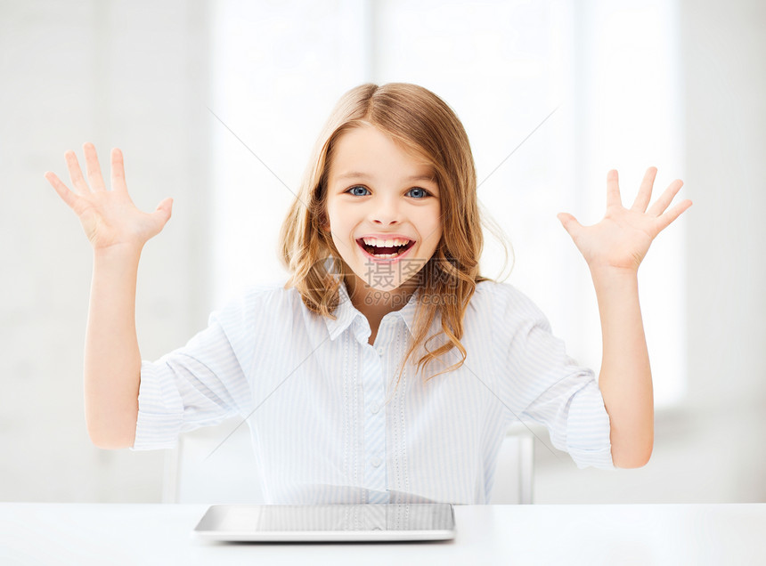 拿着平板电脑和手举手的笑笑女孩学校女孩药片家庭作业童年孩子青春期优胜者微笑小学生图片