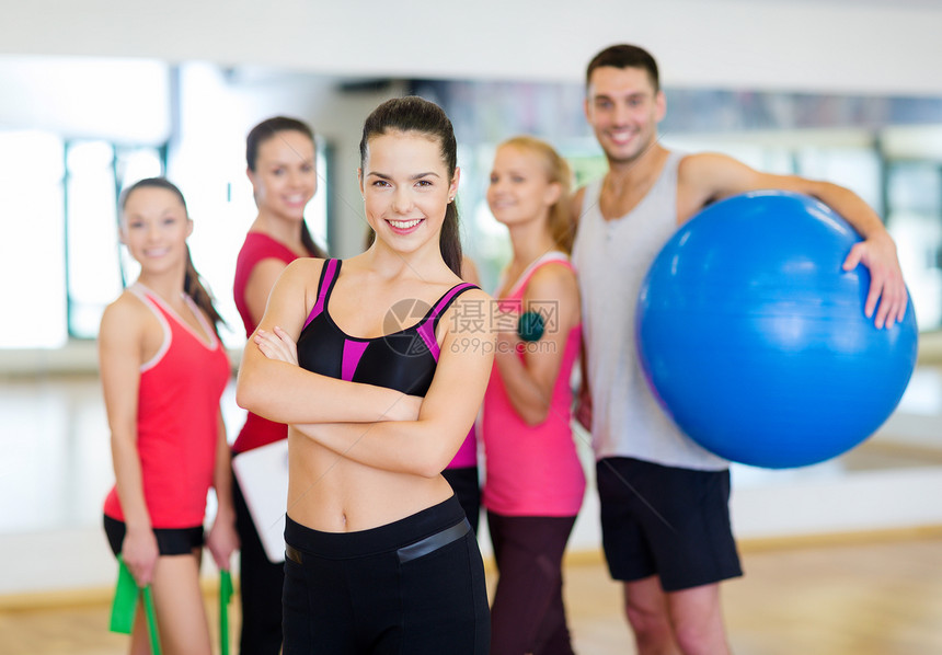 在健身房里站在团体前面的女子火车运动培训师训练团队运动员损失成年人幸福重量图片