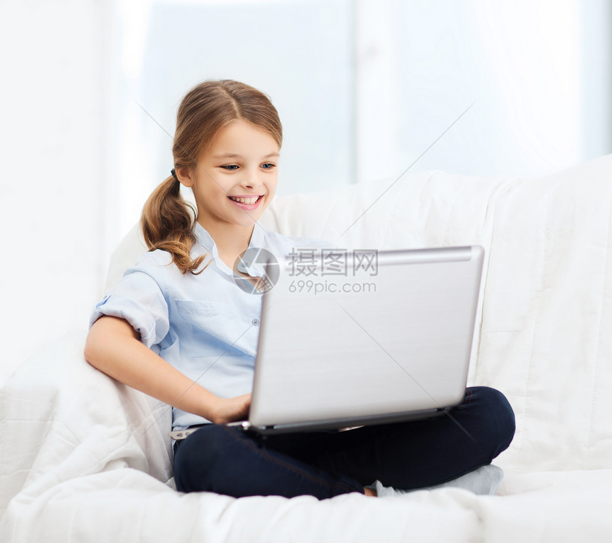 家里带笔记本电脑的笑笑女孩上网休闲小学生技术青春期玩家学习互联网瞳孔家庭作业图片