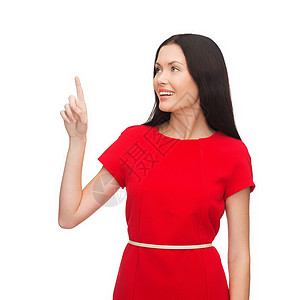 穿红裙子的年轻姑娘用手指指着她的手指红色微笑广告按钮女孩采摘幸福指挥快乐白色背景图片