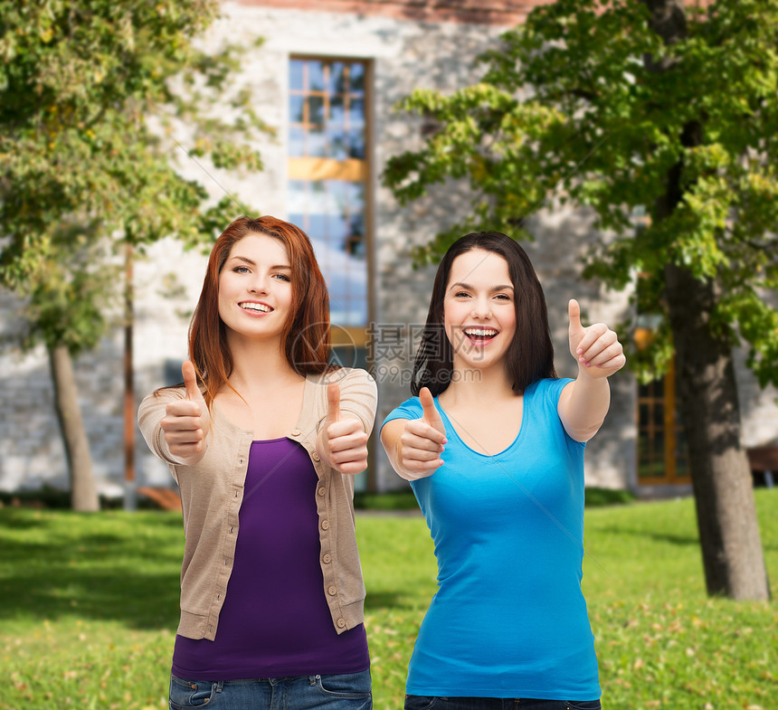 两个微笑的女孩 伸出大拇指衣服成功闺蜜乐趣学生快乐成就青年微笑手势图片