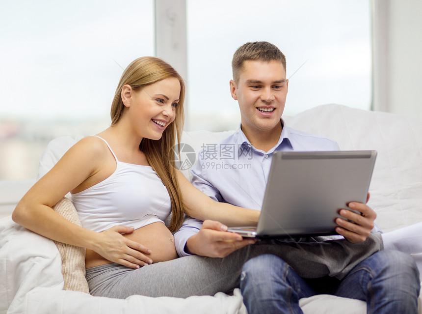 拥有膝上型计算机的孕妇家庭图片