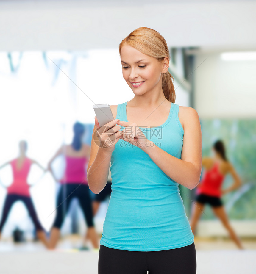 拥有智能手机的运动妇女互联网技术数字运动员女孩损失健身房重量微笑团体图片