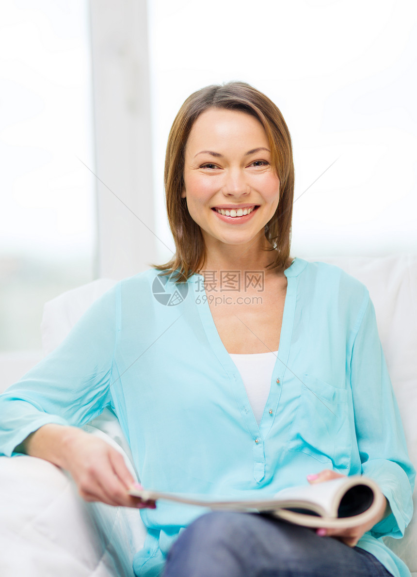 在家阅读杂志时微笑着的妇女家庭主妇家庭幸福沙发长椅报纸叶子休闲八卦妻子图片