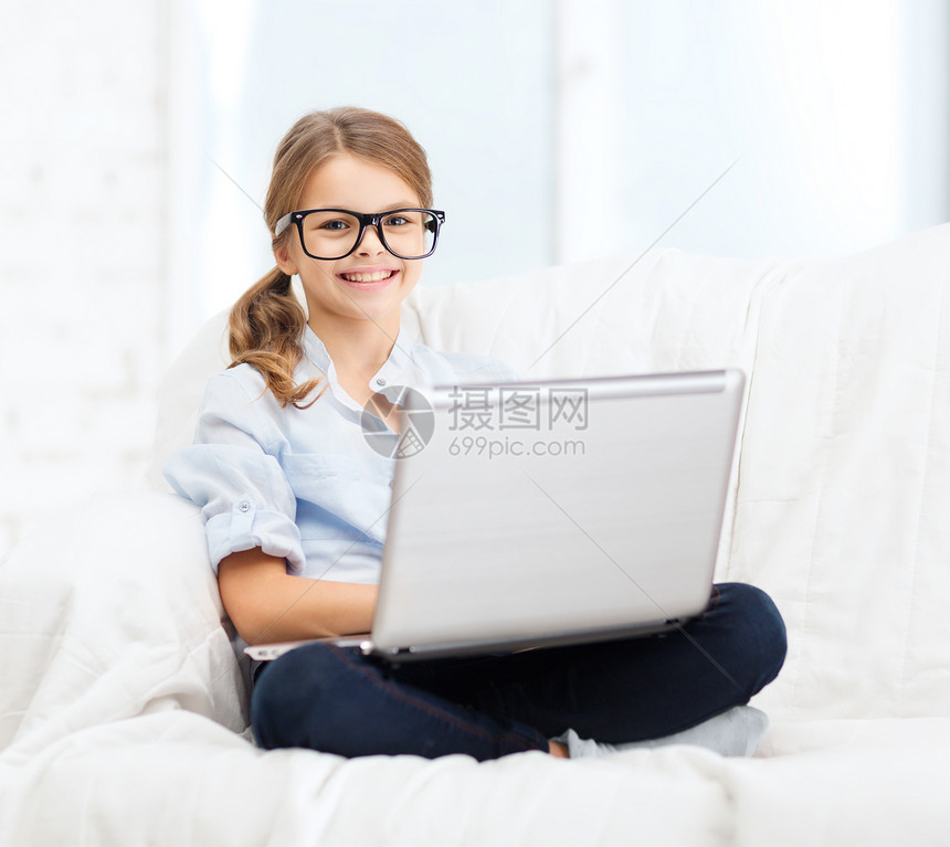 带着笔记本电脑在家的微笑着的女孩童年玩家青春期孩子互联网青少年技术家庭作业视频上网图片