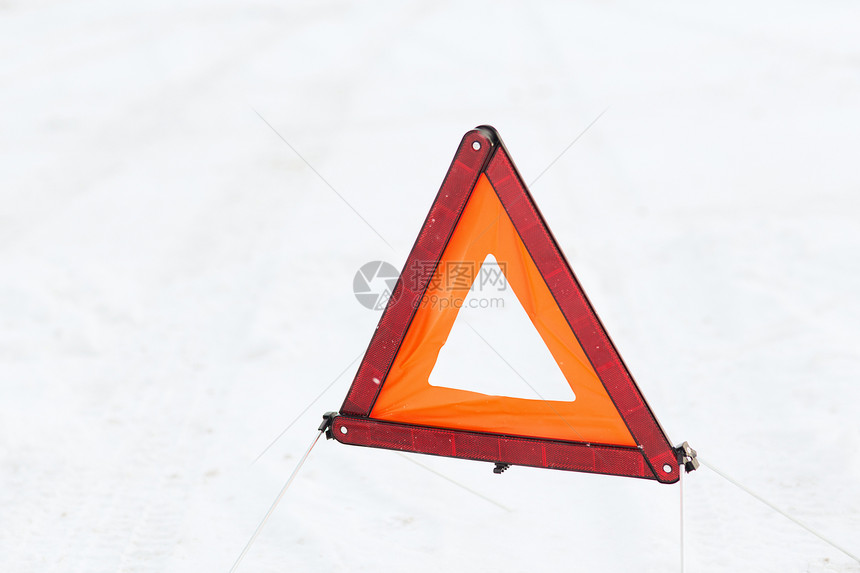 特写雪雪上的警告三角形图片