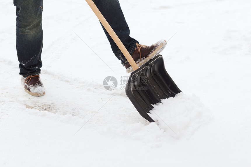 从车道上铲雪的 人暴风雪雪堆降雪房屋打扫男性工具扫帚手套风暴图片