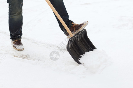 从车道上铲雪的 人暴风雪雪堆降雪房屋打扫男性工具扫帚手套风暴背景图片