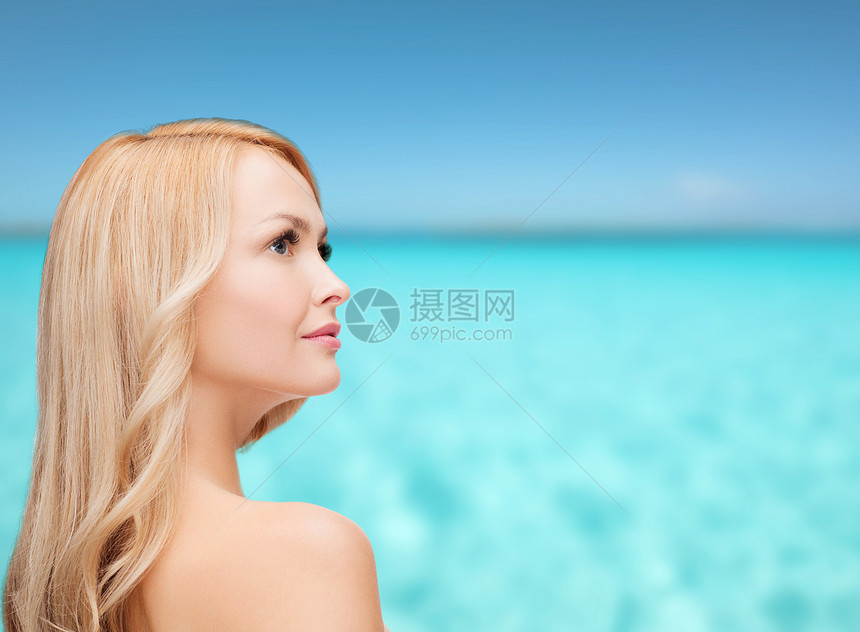 长头发的快乐女人的脸和脚趾海洋保健青年卫生护理活力肩膀蓝色福利金发女郎图片