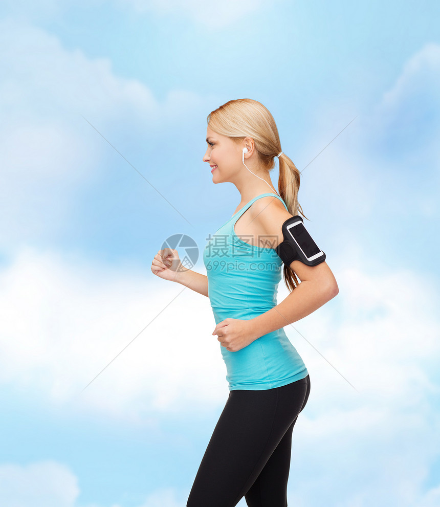 运动妇女用智能手机和耳机奔跑手臂歌曲跑步赛跑者女孩臂章蓝色微笑数字耐力图片