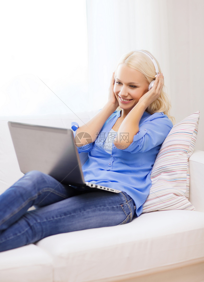 家中拥有膝上型计算机和耳机的妇女女性成人播客收音机笔记本工人女孩音乐互联网歌曲图片