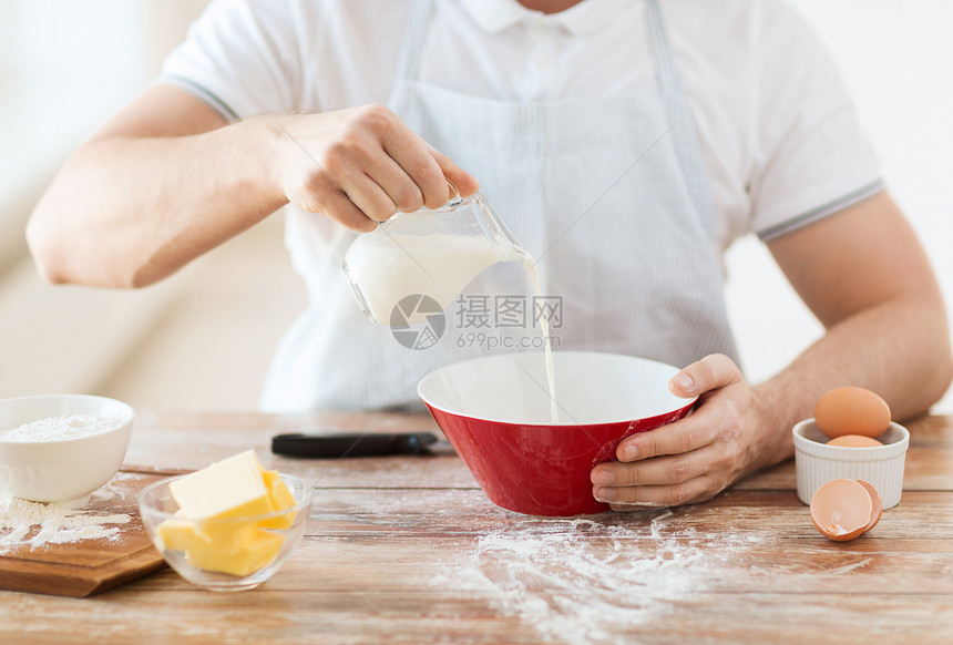 紧紧的男性手 在碗中浇满乳汁殴打营养男性围裙食物甜点饼子厨师男人木板图片