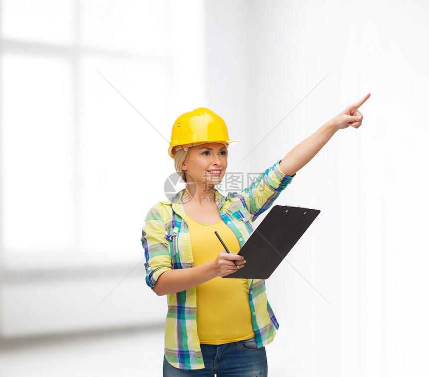 带着剪贴板戴头盔的笑着女人窗户建设者房间工人建筑安全维修工程师工作女性图片