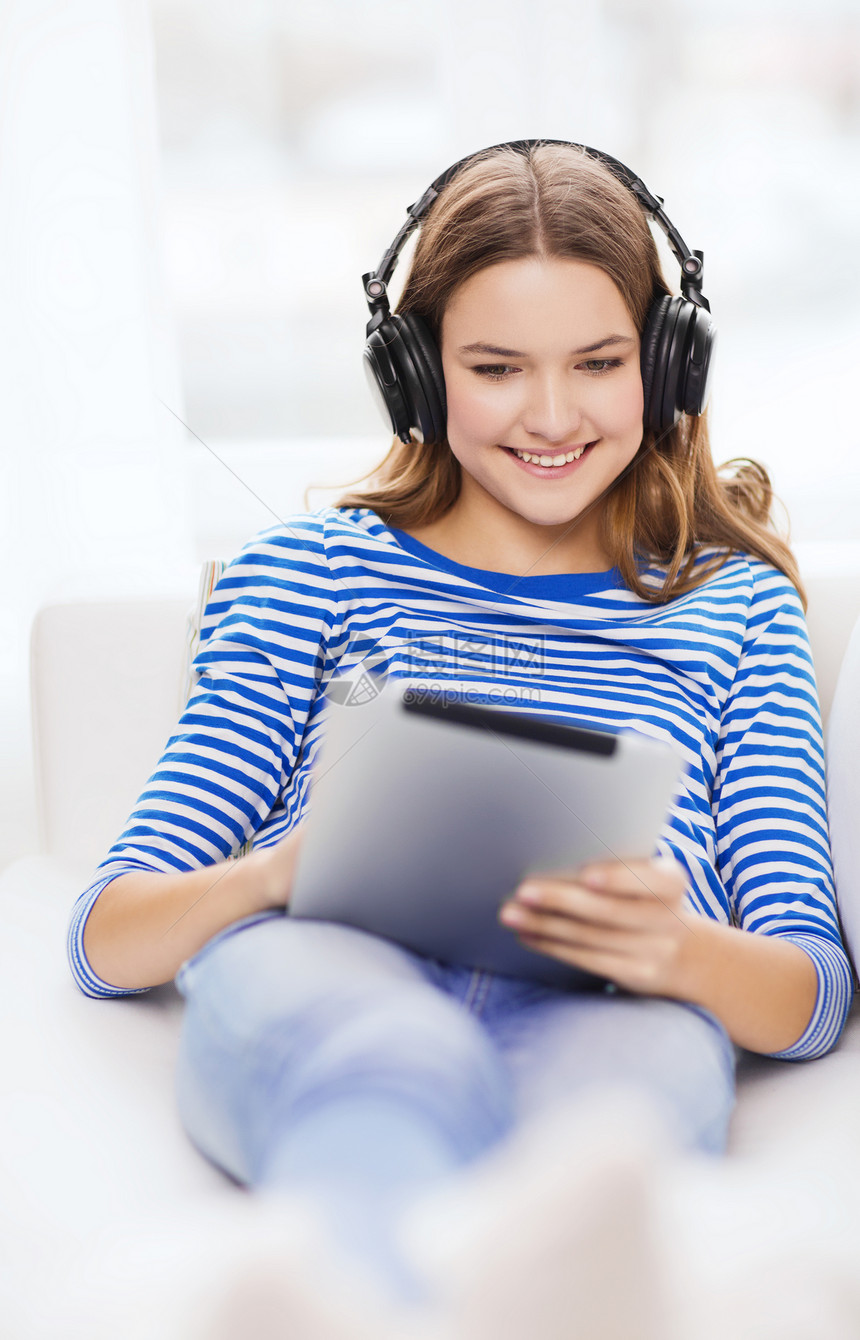 家里有平板电脑和耳机的女孩沙发药片博客成人工人闲暇青少年微笑播客音乐图片